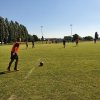 Zdjecie przedstawia boisko wraz z pilkarzami
